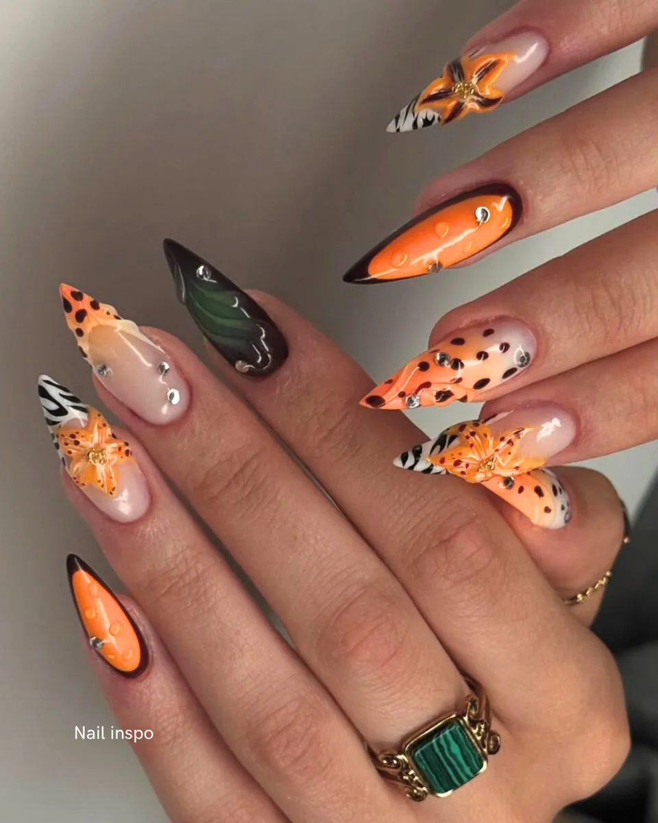 Autumn-toned almond nails with painted leaves and animal-print art