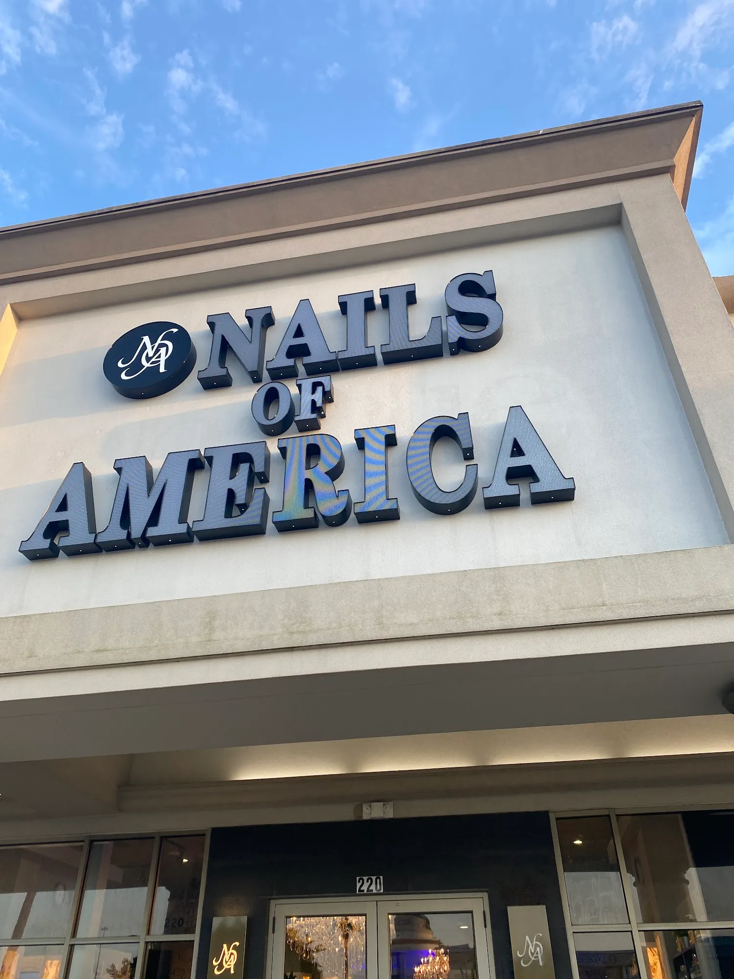 Exterior storefront sign of Nails of America at Meyerland Plaza, Houston
