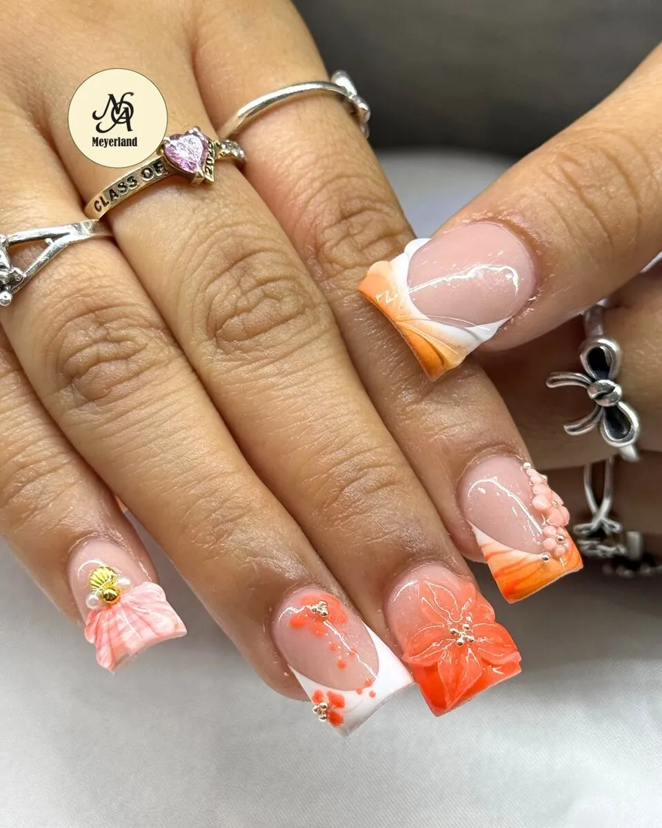 White and orange French coffin nails finished with a sculpted 3D bow